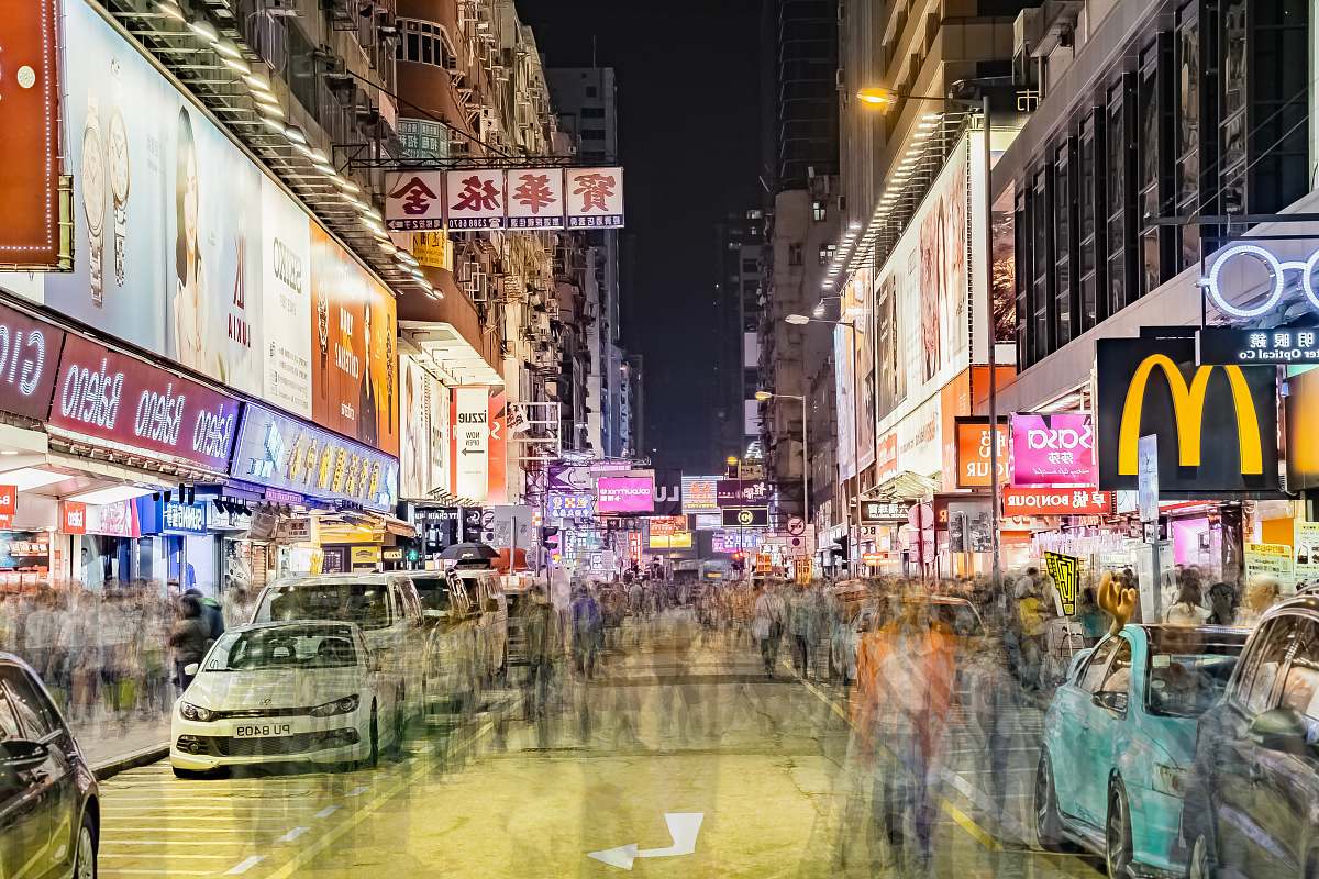 city people walking on street with cars on roadside at nighttime downtown