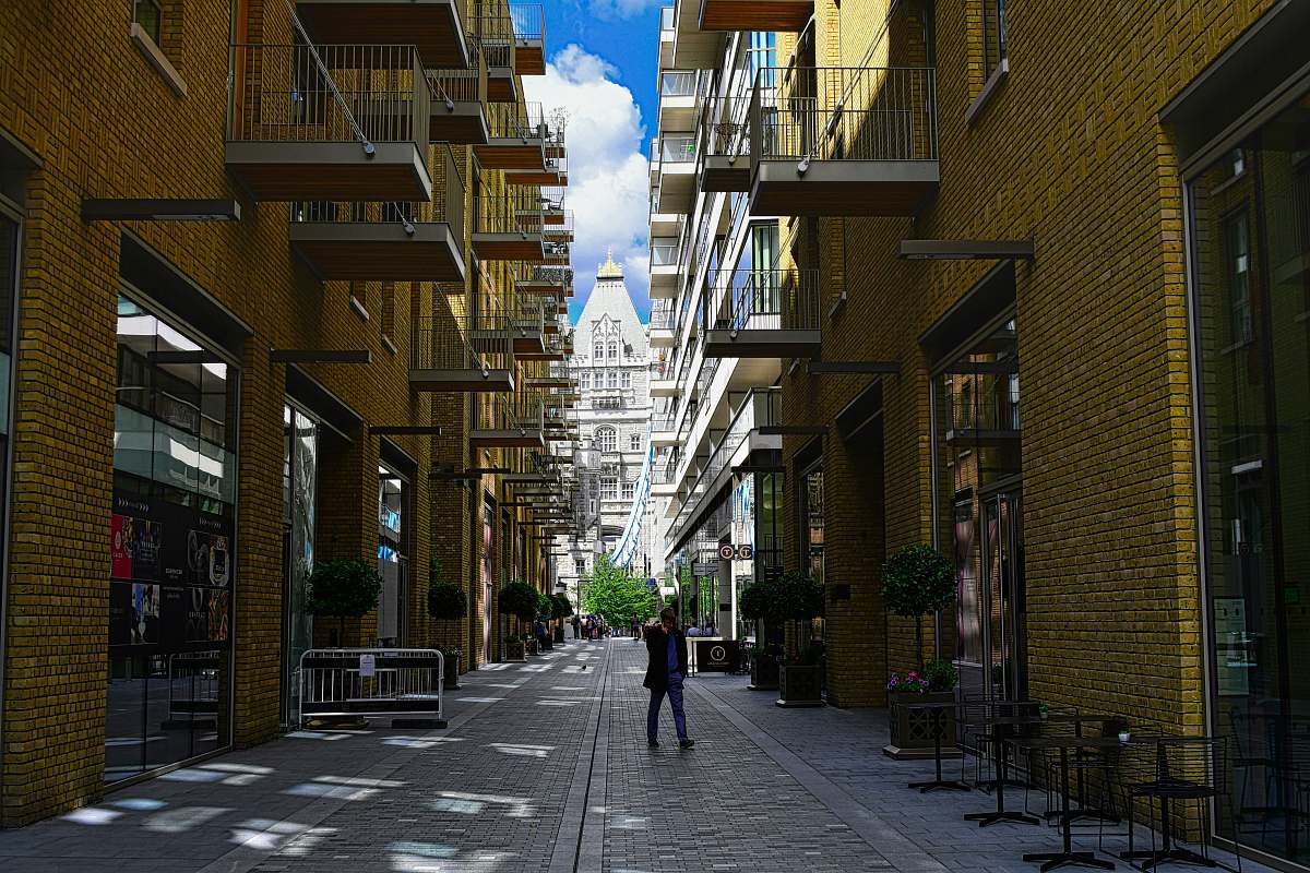street person standing between buildings town