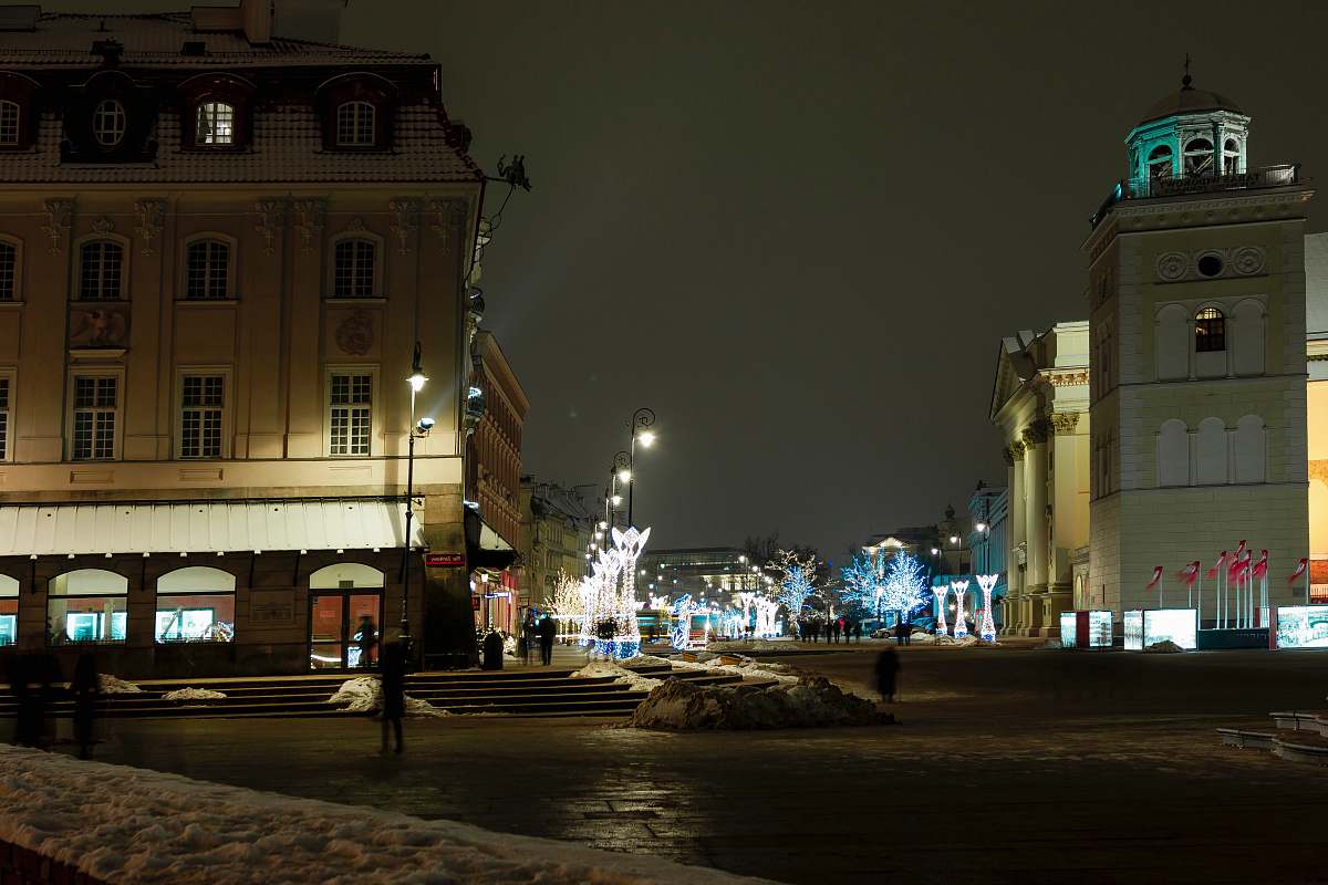 city person standing on road at night-time town