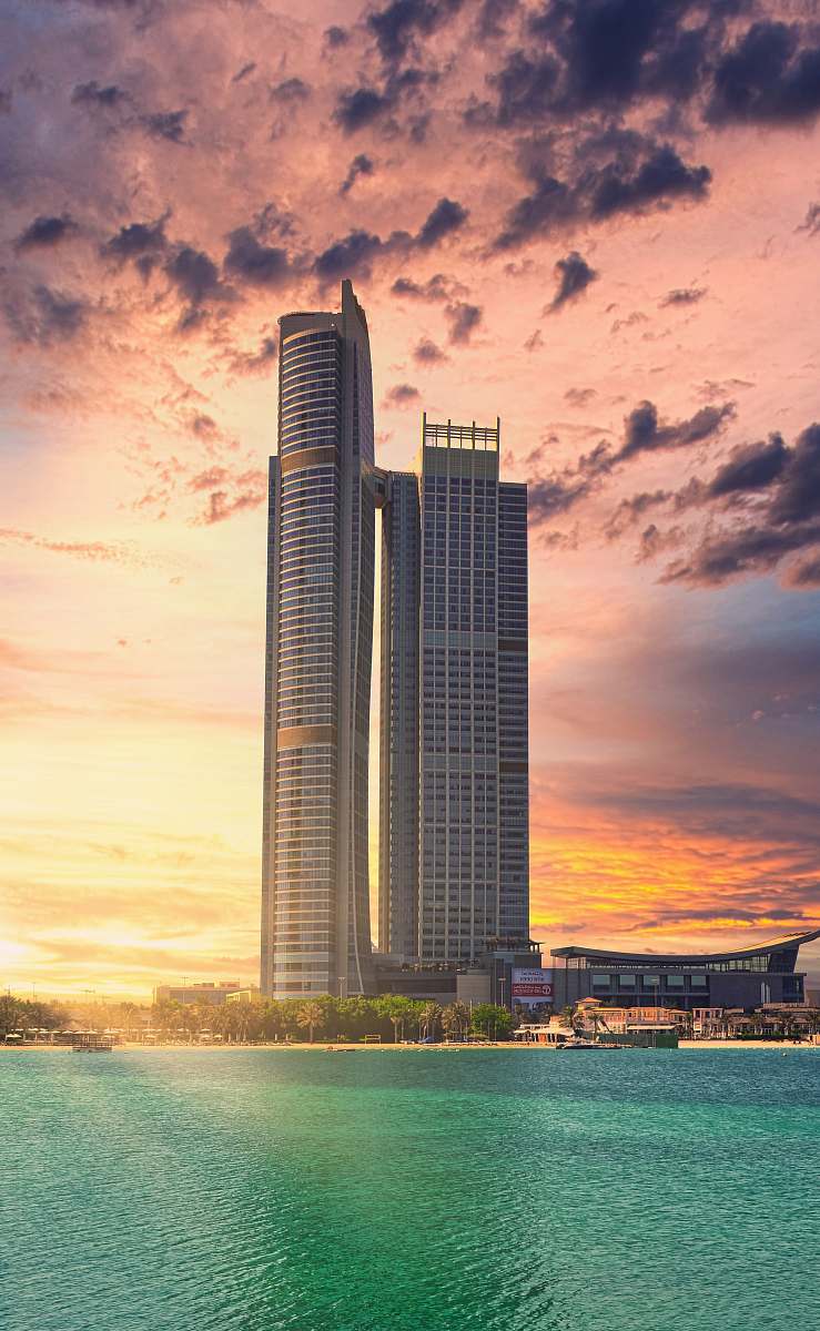 city photography of gray high-rise building beside body of water during daytime high rise