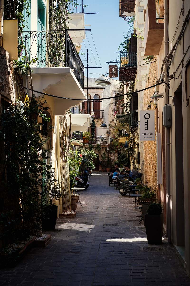Discover the enchanting beauty of a narrow alleyway flanked by charming buildings, where vibrant plants cascade gracefully from urban structures. This picturesque scene captures the essence of urban greenery, perfect for use in travel blogs, lifestyle magazines, or nature conservation campaigns. Ideal for those looking to showcase the harmonious blend of architecture and nature in city environments.