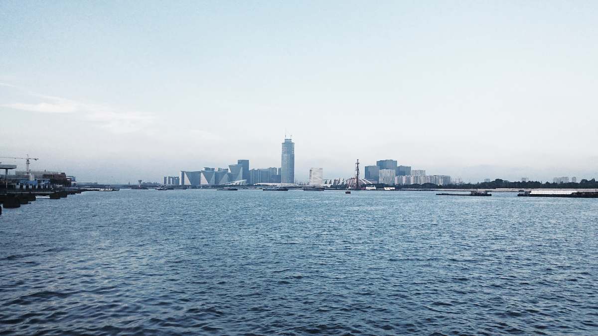 city tall city buildings seen across the harbor town