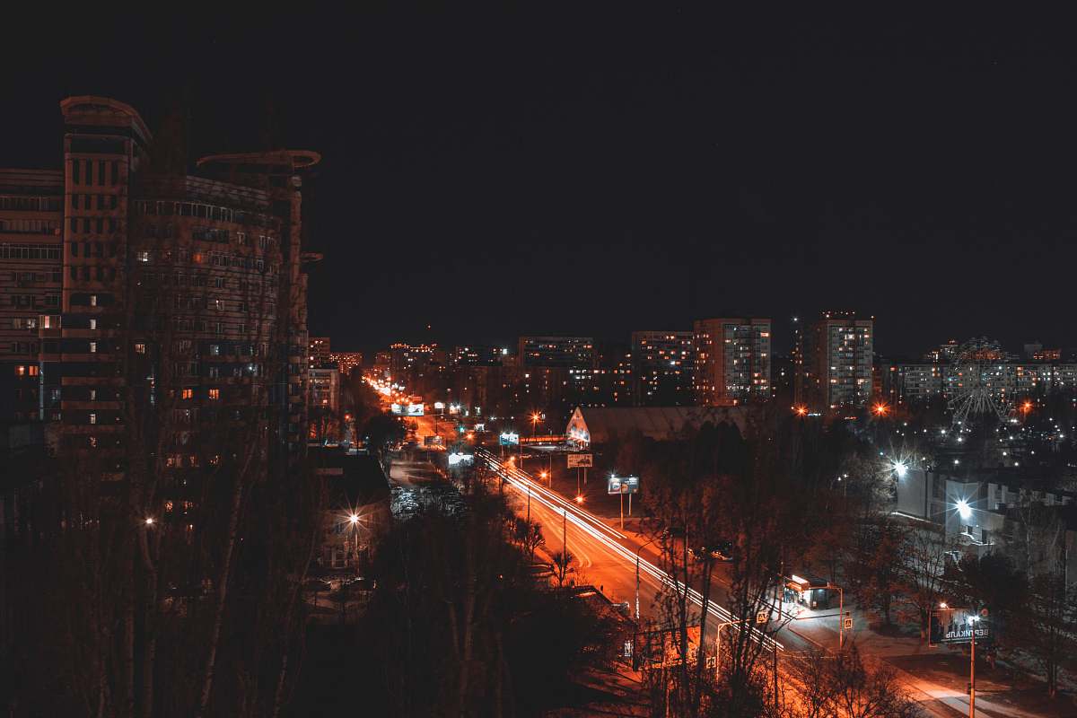 city time lapse photography of vehicles and buildings at night time metropolis