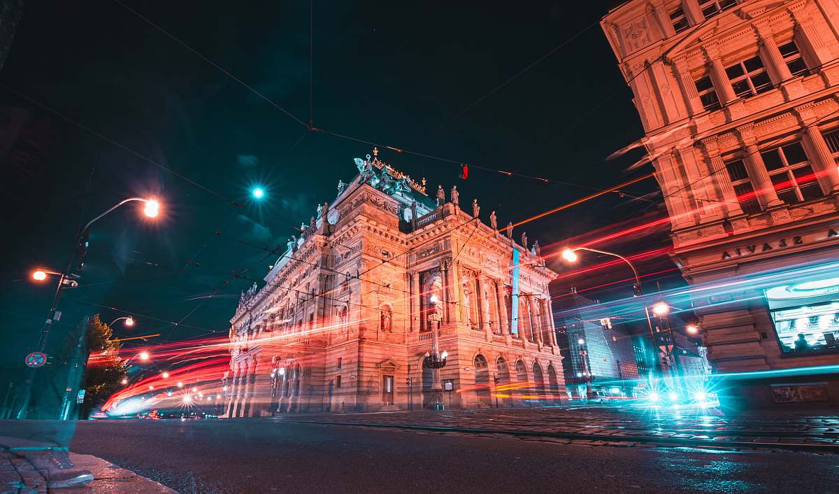 city time lapse photography of vehicles passing by outside European-styled building downtown