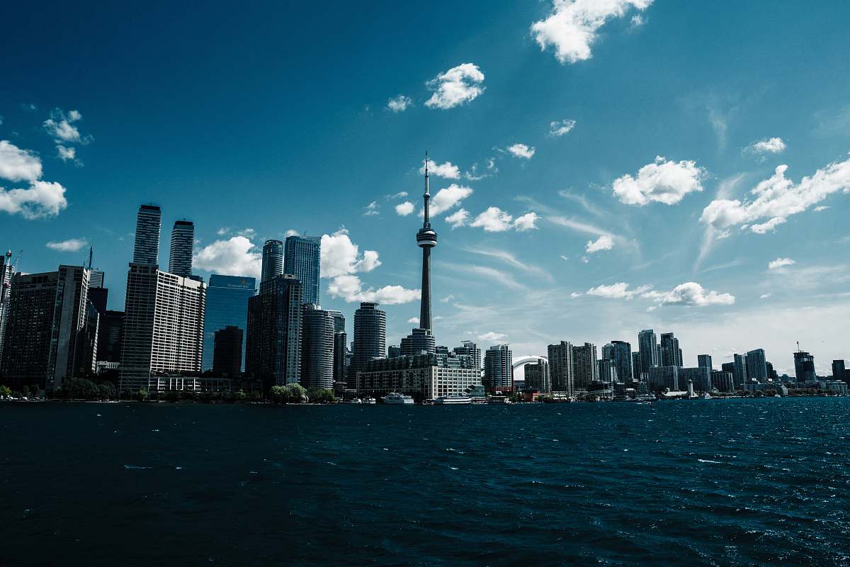 city tower and buildings near blue sea high rise