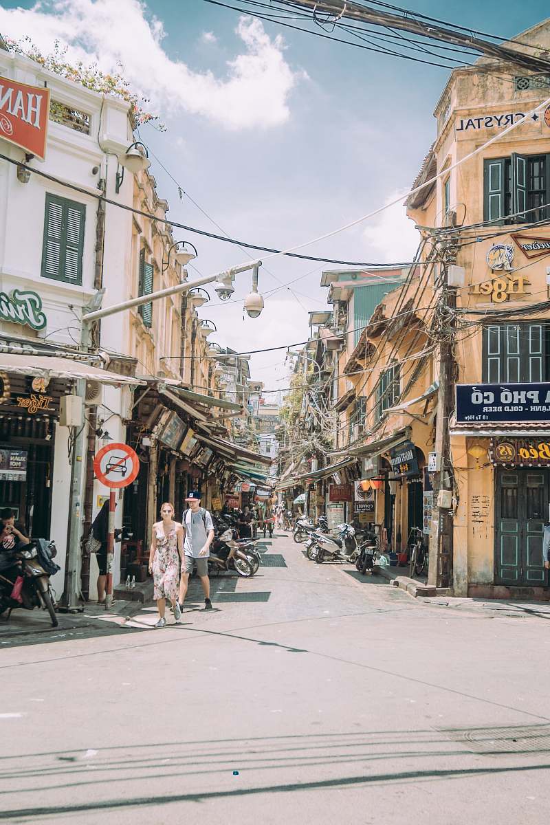 city two person walking on road beside building road