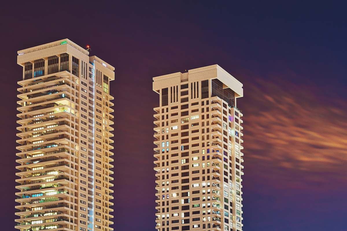 condo two white high-rise buildings at night time housing