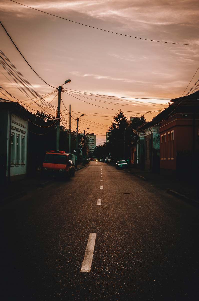 city vehicles parked beside road during sunset street