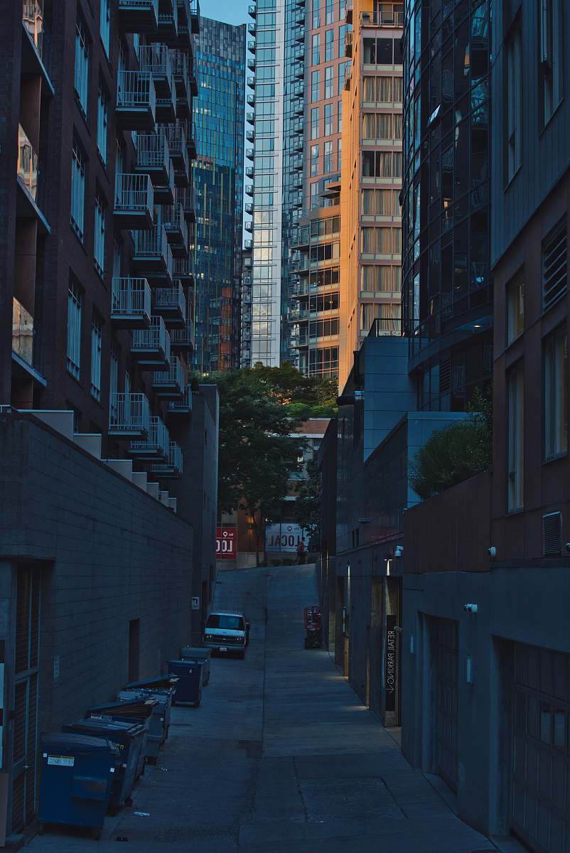 city vehicles parked in between concrete buildings urban