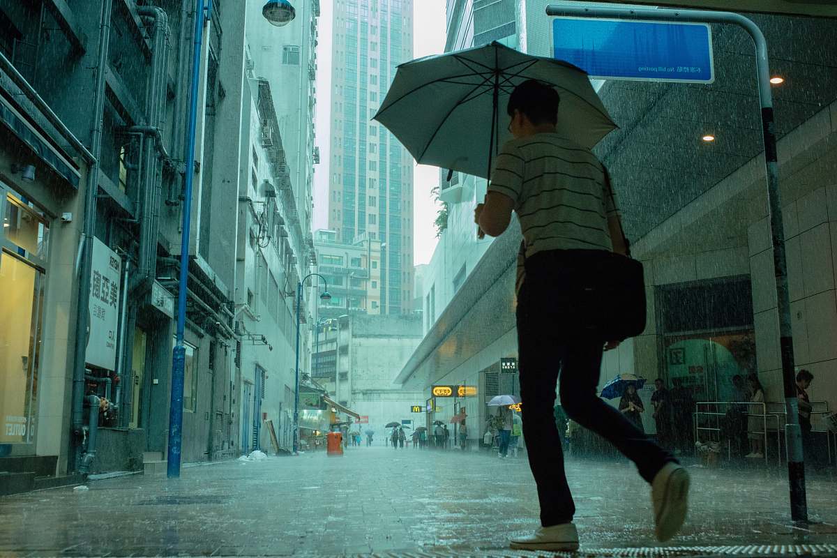 human woman walking on street while its raining person