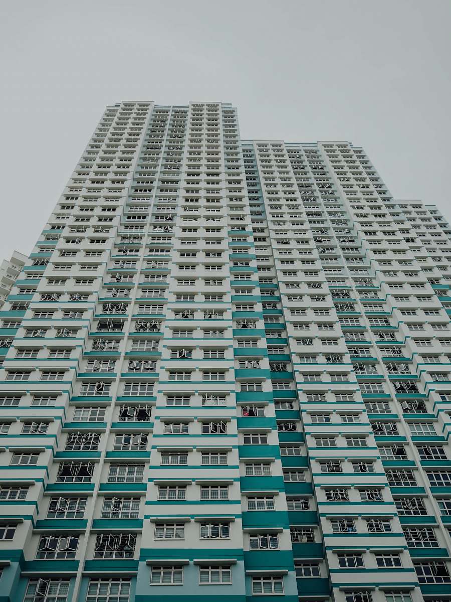 city worm view photo of white and teal building during daytime high rise