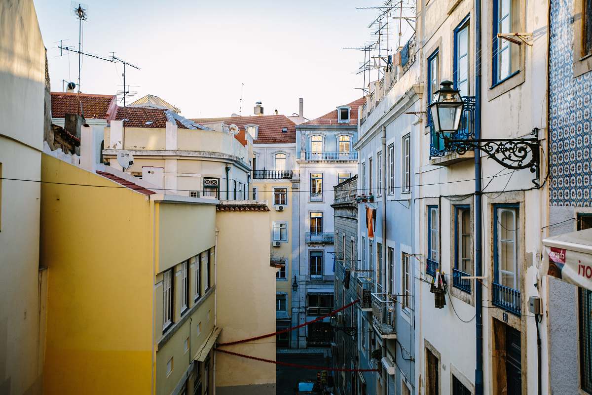 city yellow and white building at daytime alley