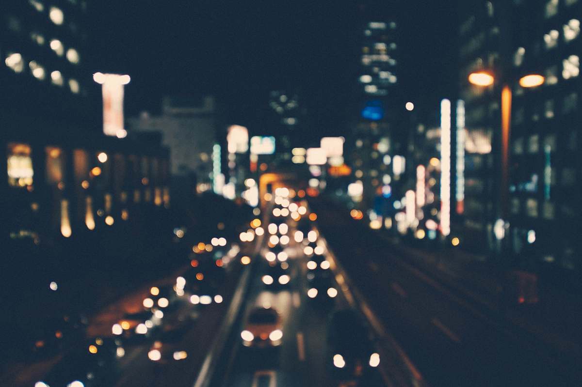 Road A Blurry Shot Of A City Street Lit Up By Buildings And Cars At ...