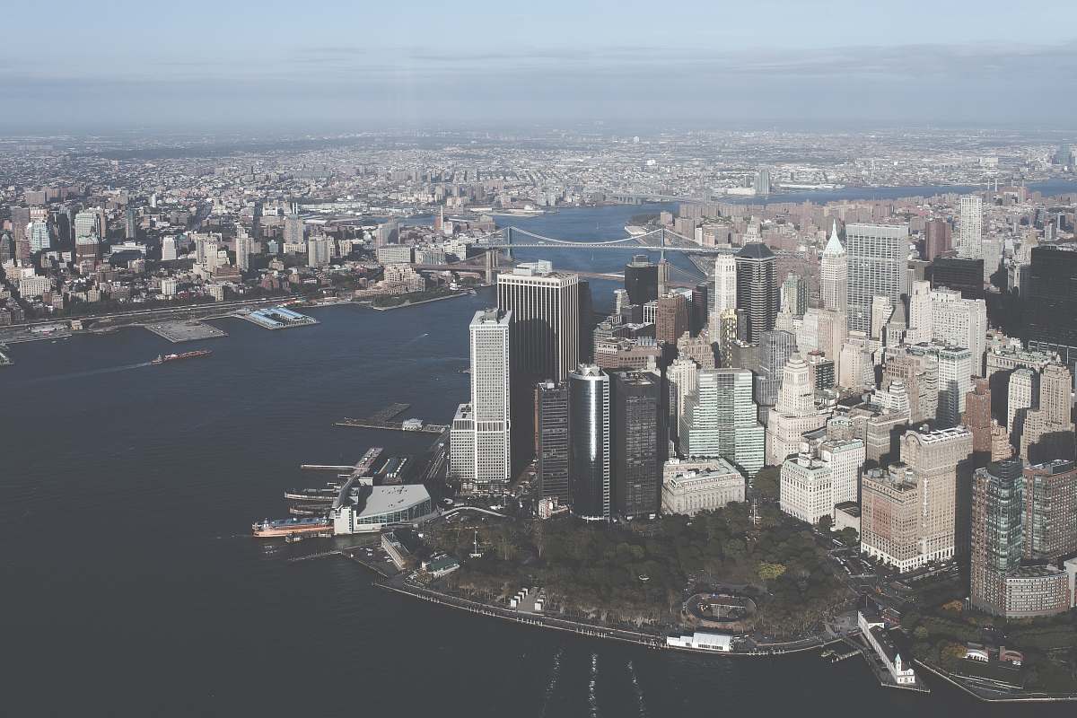 Experience the breathtaking beauty of a vibrant urban landscape captured from an aerial perspective. This stunning image showcases a dynamic city skyline, gracefully nestled alongside a shimmering body of water. Ideal for use in travel brochures, real estate marketing, or urban planning presentations, this photograph highlights the interplay between architecture and nature, making it a versatile addition to any visual content library.