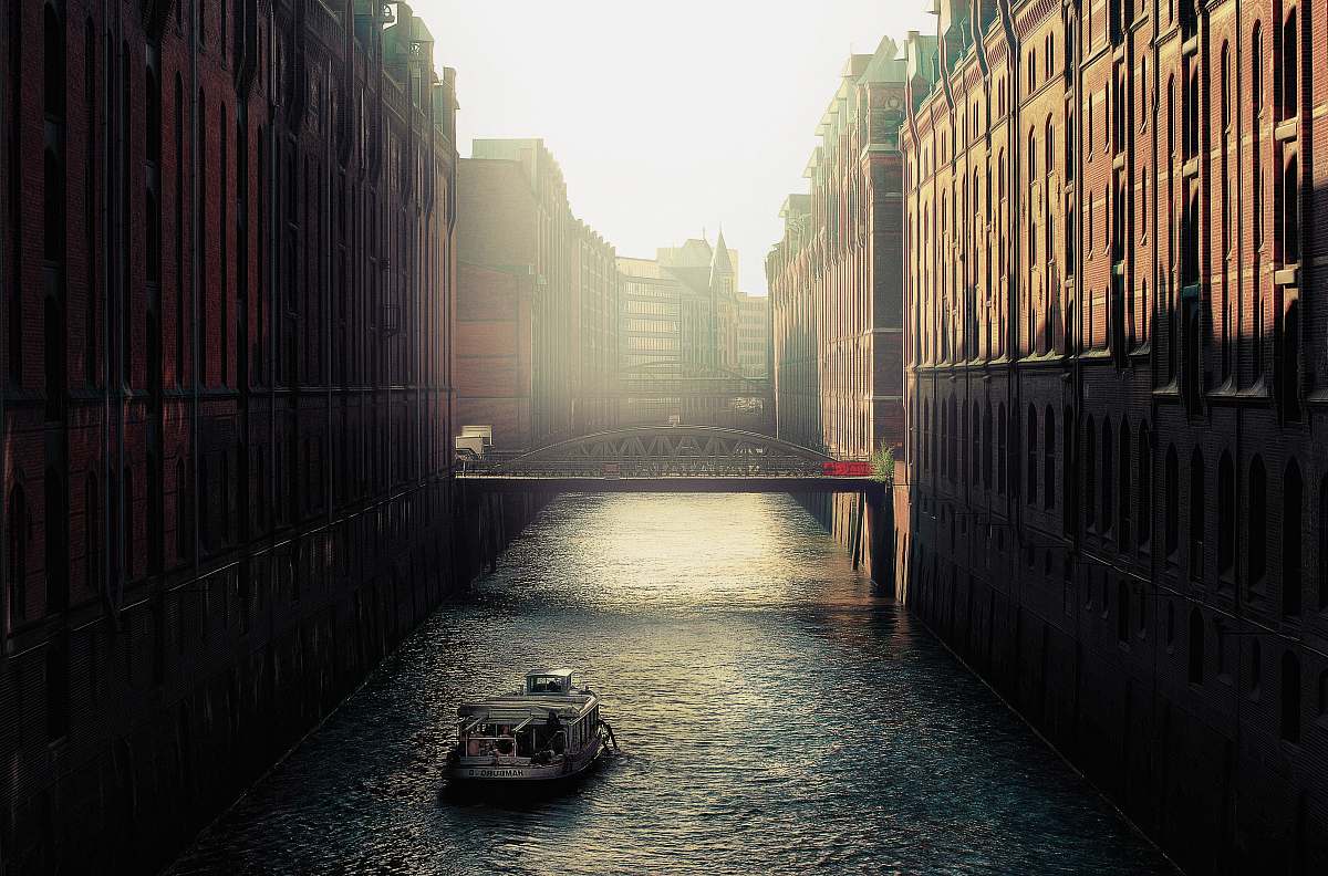 transportation boat on body of water between highrise buildings canal