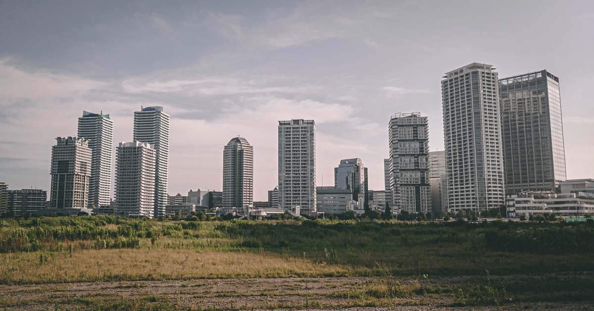 building city high-rise buildings beside grass field high rise