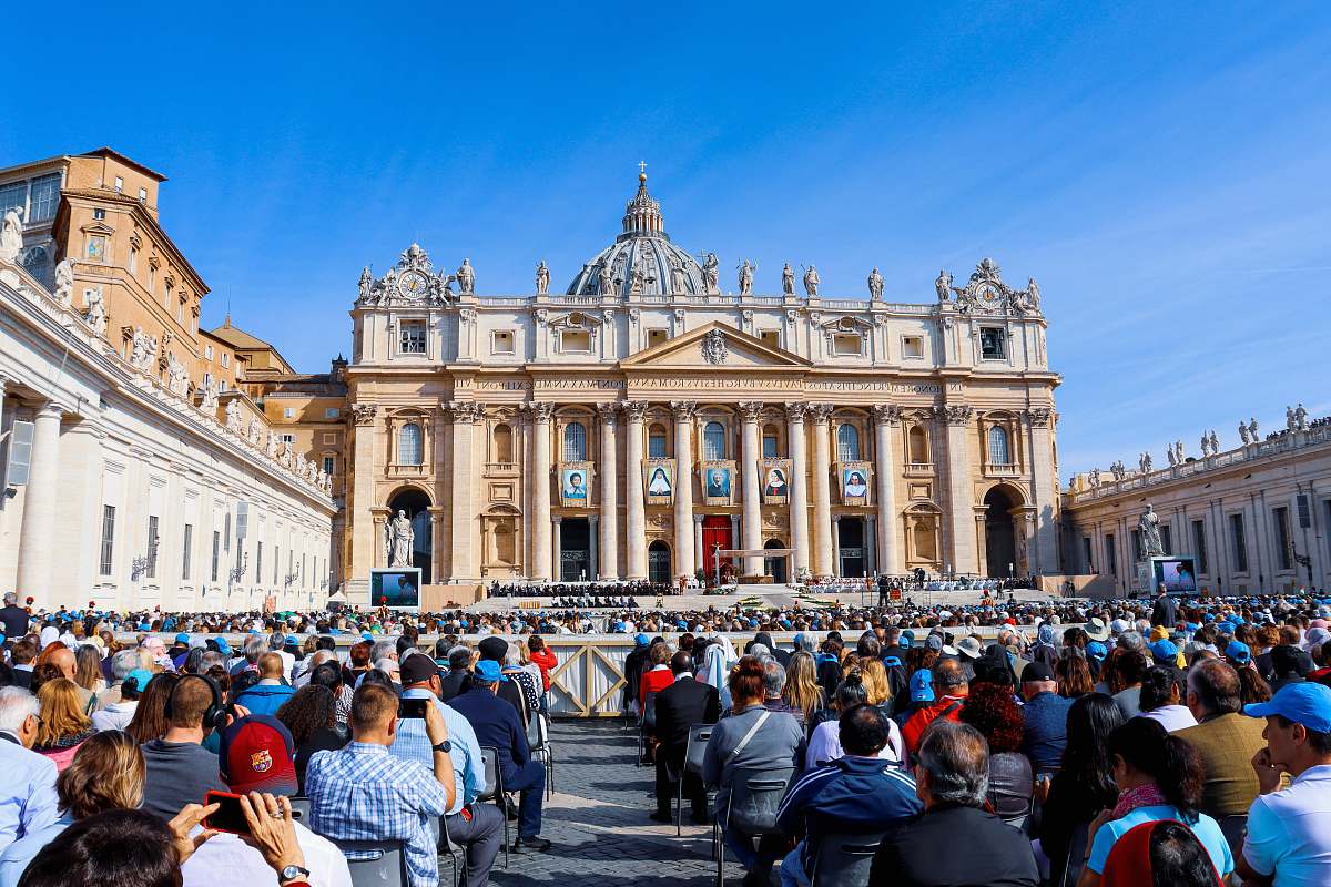 building crowd of people sitting in front of a cathedral downtown