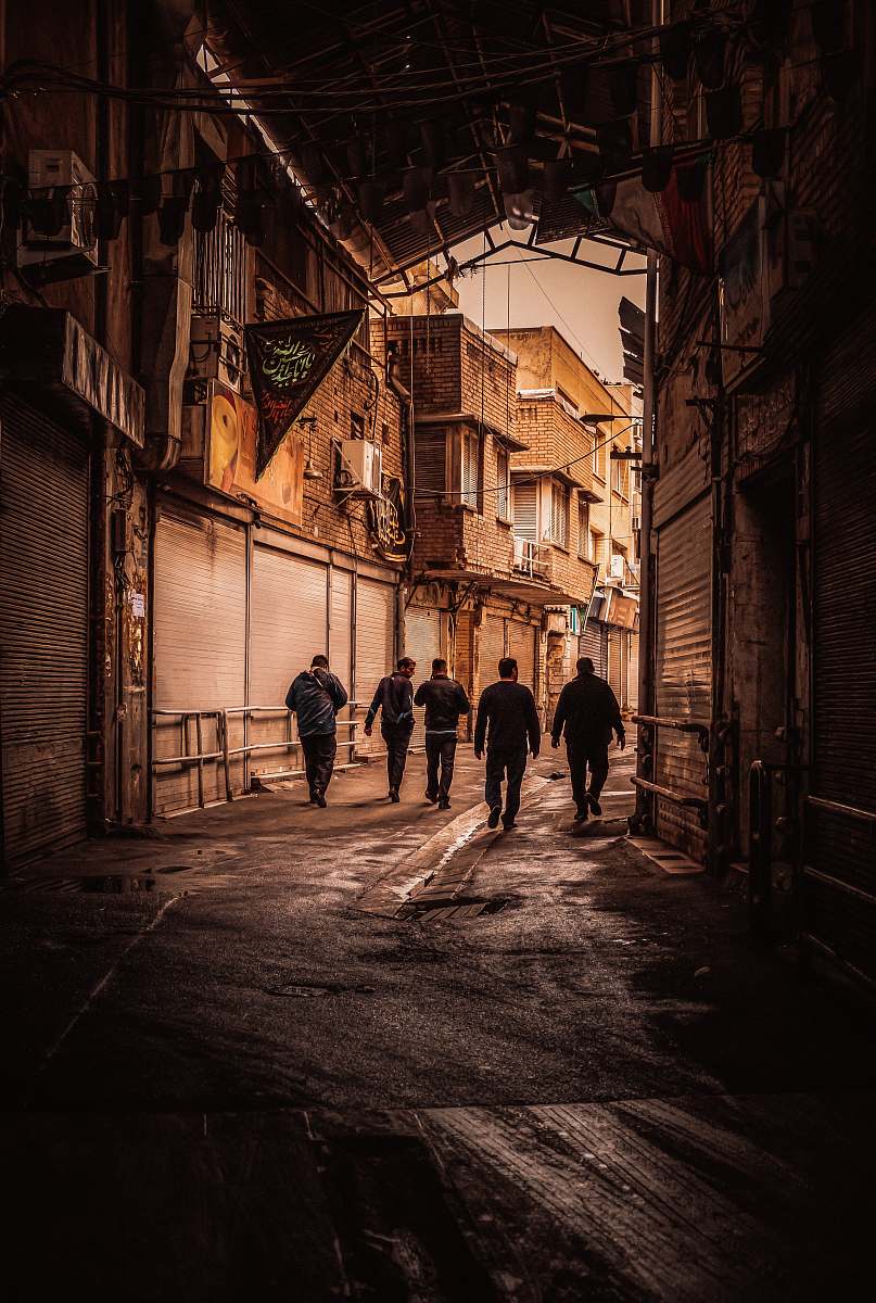 street five men walking on the pathway in between of buildings urban