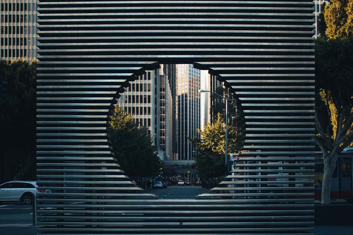 car gray concrete building with hole near green trees during daytime cityscape