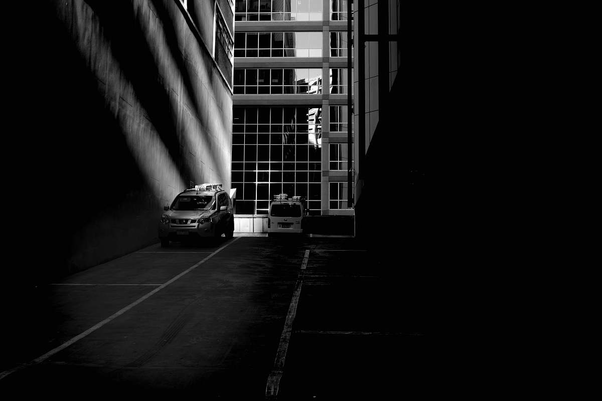 urban grayscale photo of parked silver SUV black-and-white