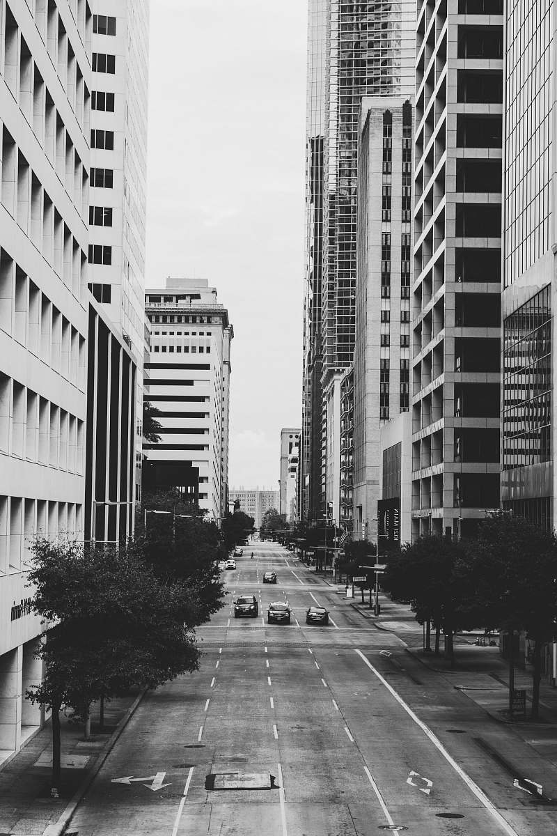 black-and-white grayscale photo of vehicles on road and buildings urban