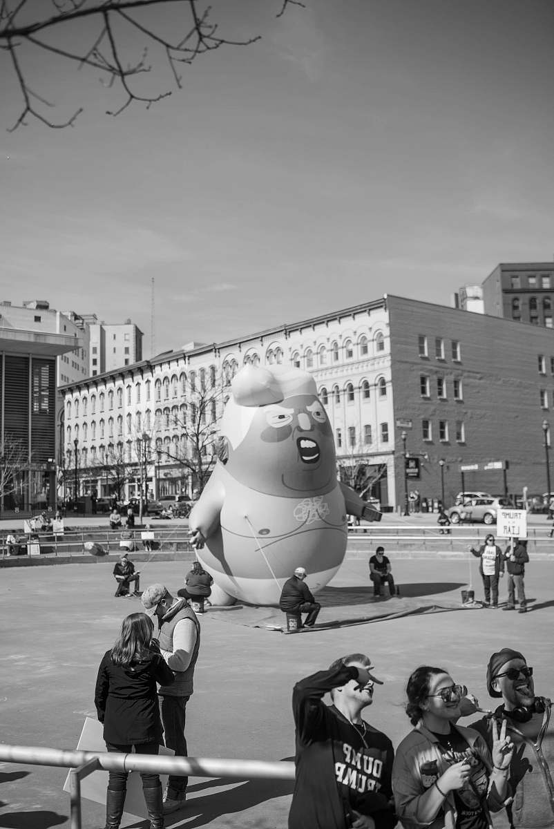 building grayscale photography of people walking near large statue black-and-white