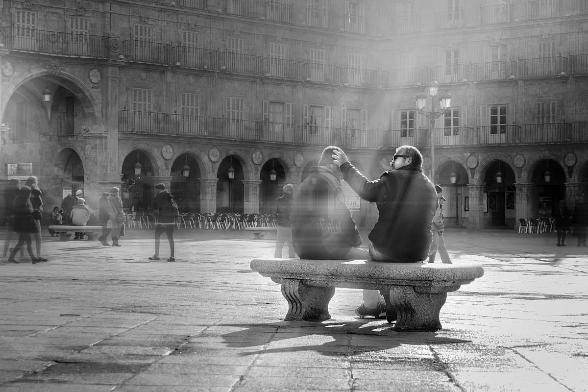 building grayscale photography of person holding another person black-and-white