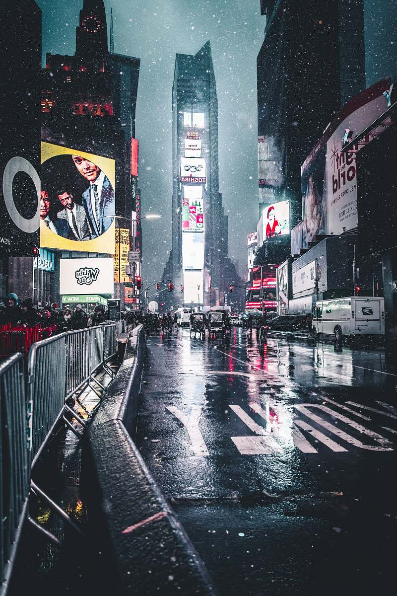 building group of people behind barricades on sidewalk during nighttime new york