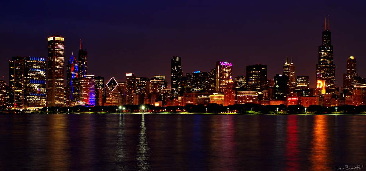 building lighted buildings near ocean during nighttime metropolis