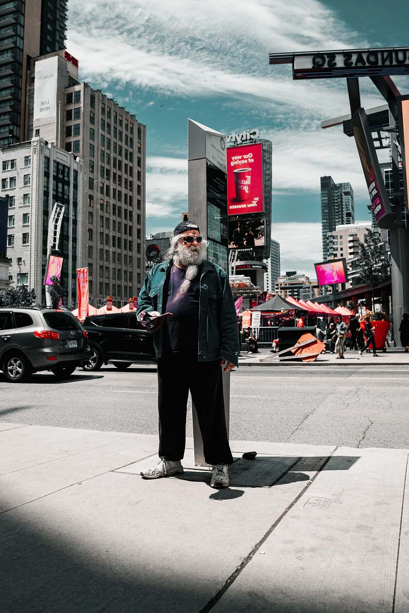 building man standing beside road on focus photography metropolis