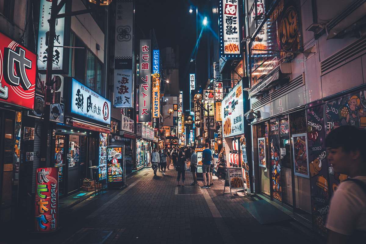 road man standing beside store facade town