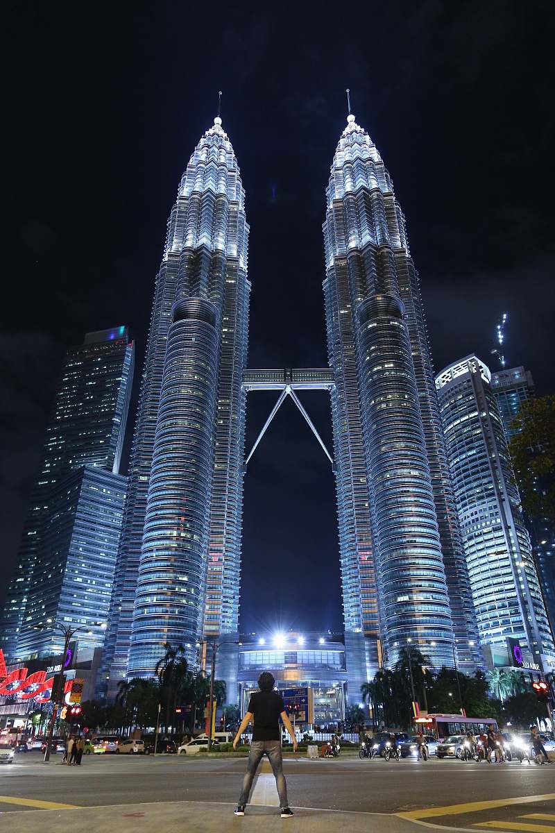 human man standing in front of Petronas Twin Tower person