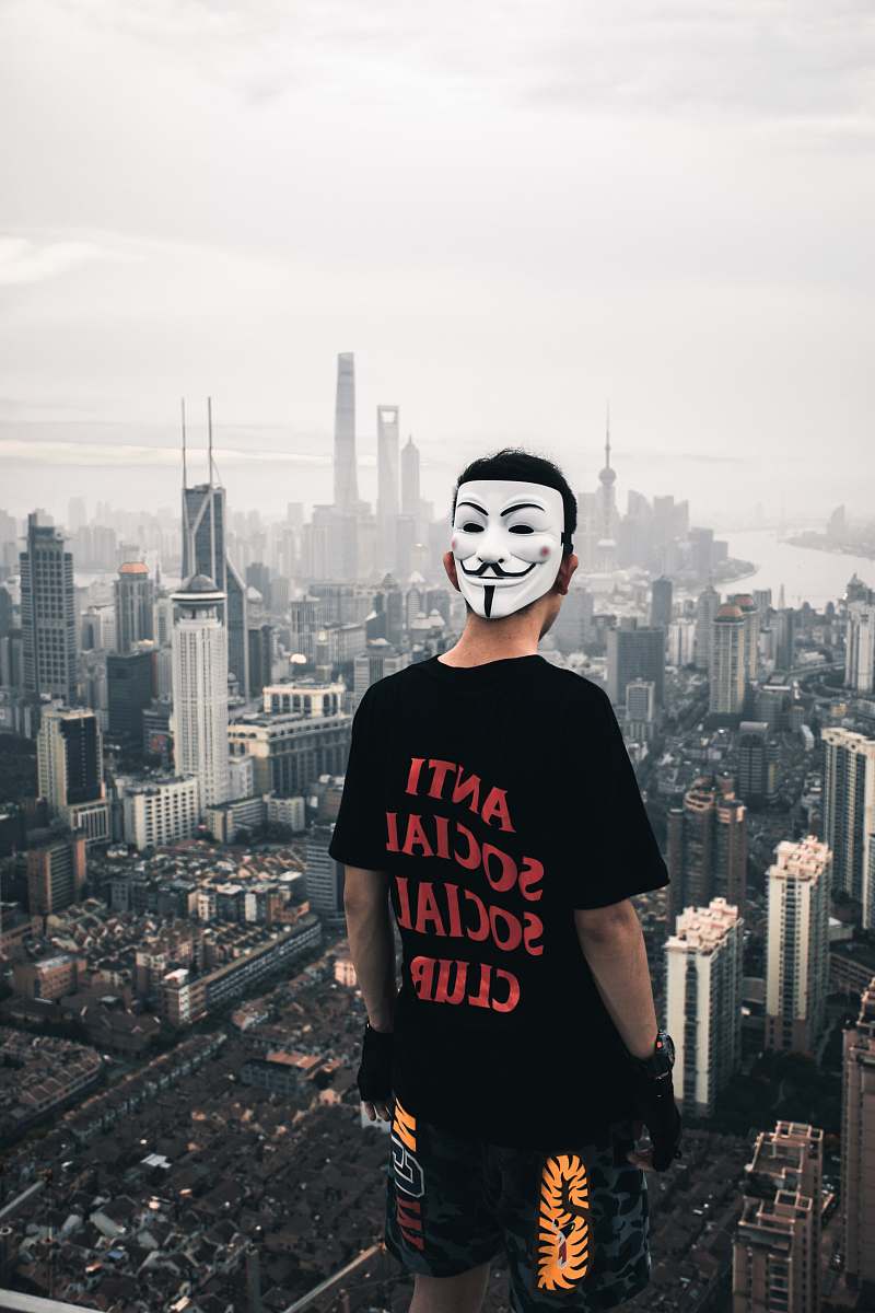 person man standing on rooftop facing high rise buildings human