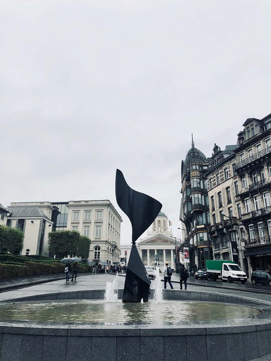building outdoor fountain under white sky downtown