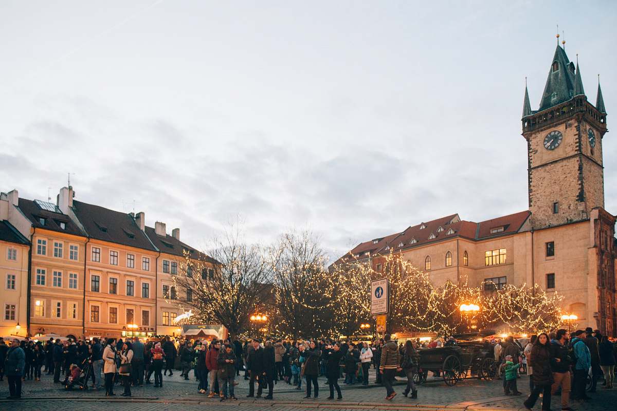 urban people standing near road beside brown castle under white sky during daytime downtown