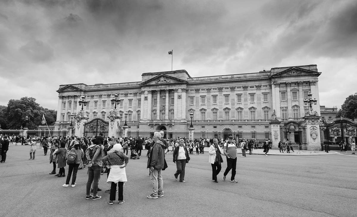 building people standing outside building in grayscale black-and-white