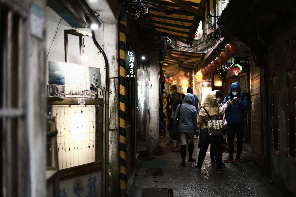 building people walking on narrow pathway road