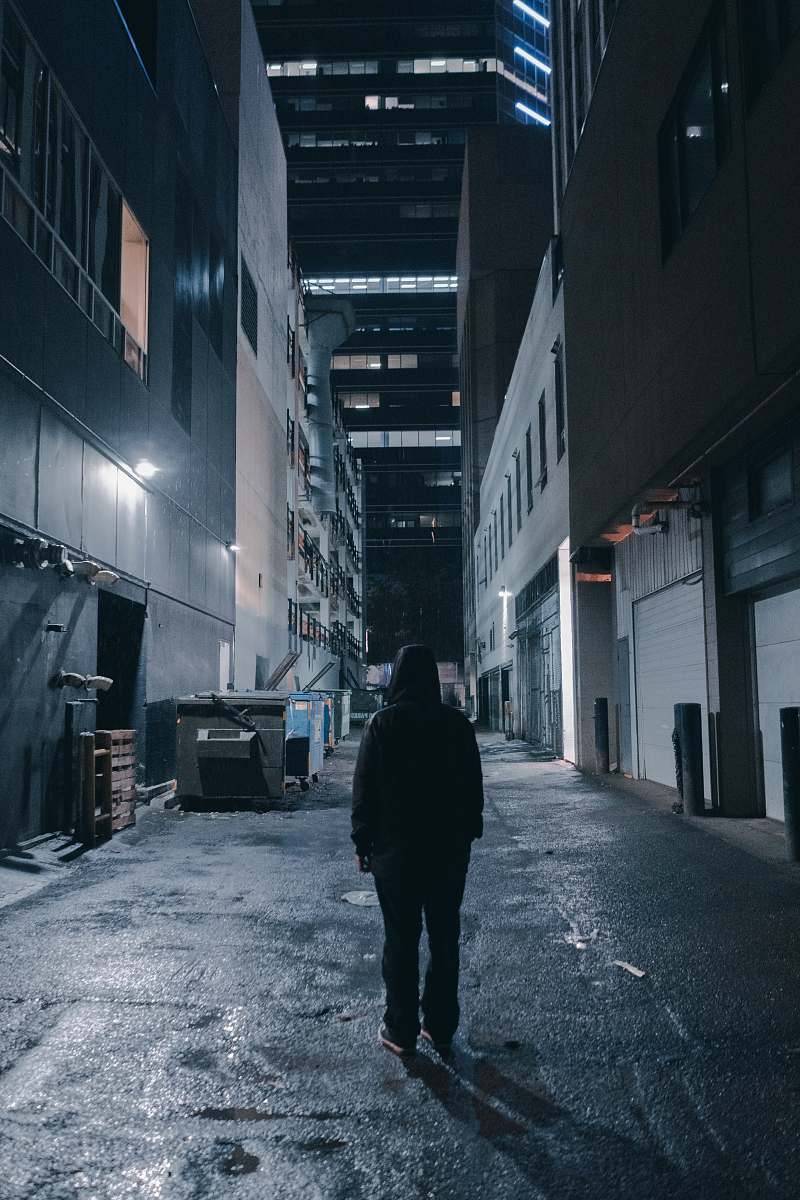 building person in a alley during nighttime with lights road