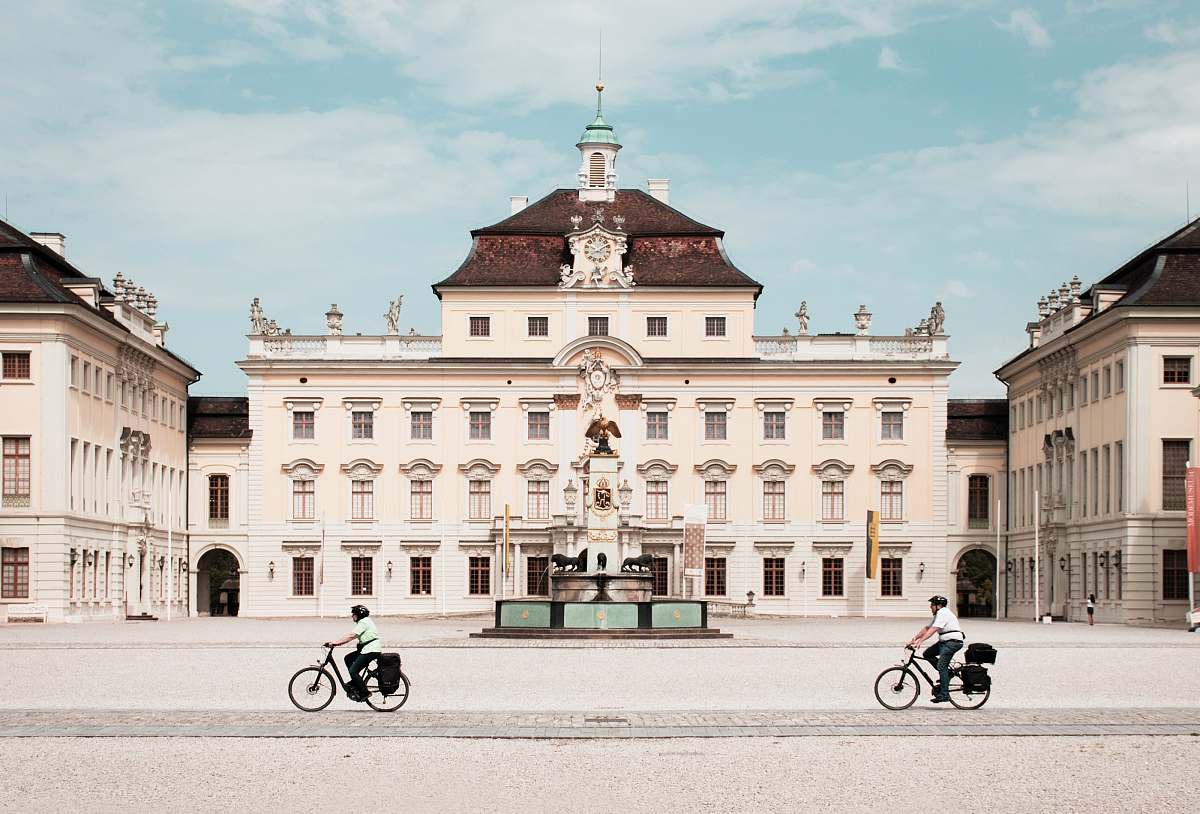 building person riding bike in front of white building during daytime town