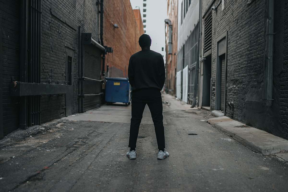 road person standing at alleyway building