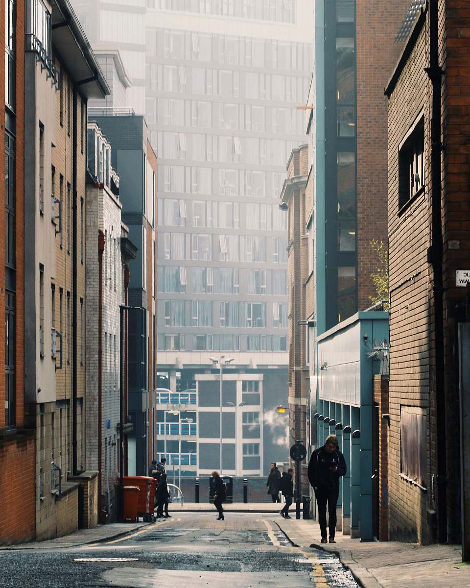 building person walking along the alle street