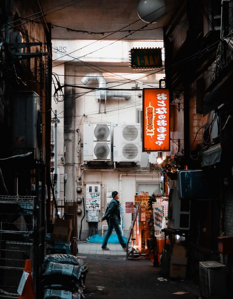 building person walking near air condensers road