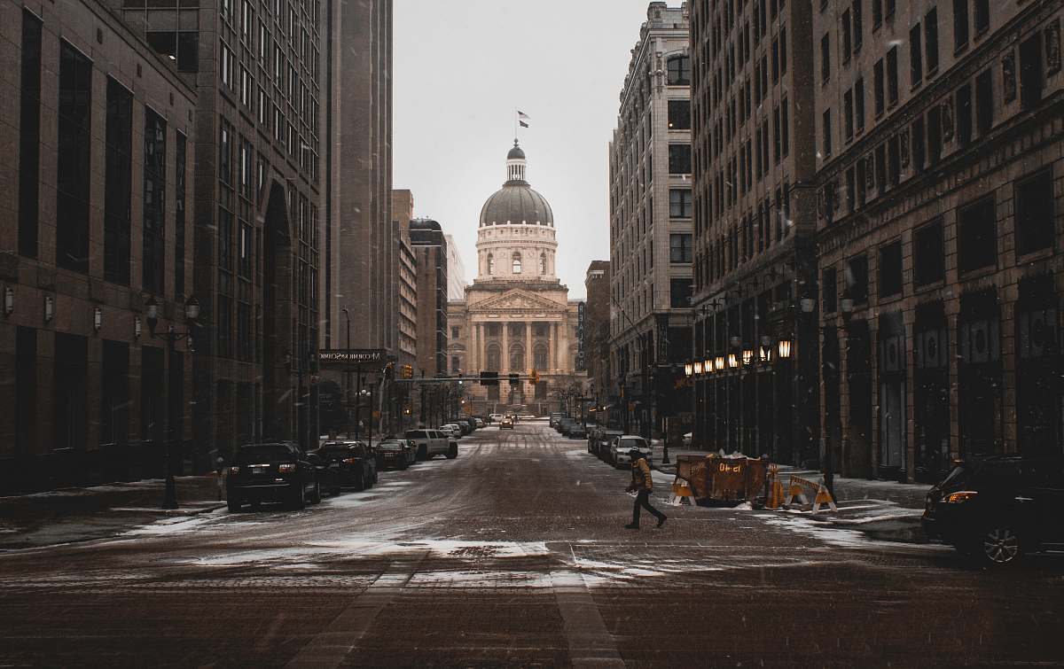Capture the essence of urban life in this vibrant scene where a solitary figure strolls along a bustling city street, flanked by modern buildings. In the background, a stunning church adds a touch of history and culture to the contemporary landscape. This image is perfect for projects related to city life, architecture, tourism, and urban exploration. Ideal for blogs, travel websites, and marketing materials that seek to illustrate the juxtaposition of modernity and tradition.
