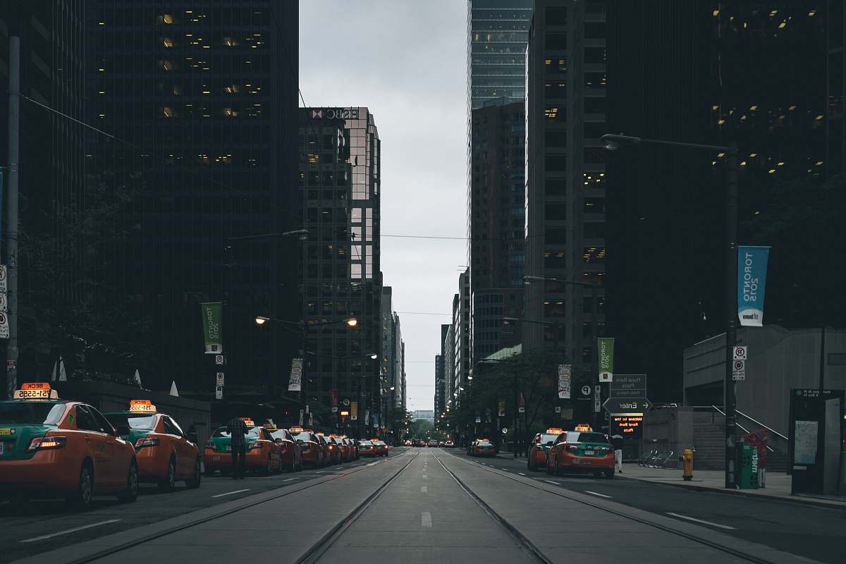 road photo of orange cabs parked on pavement near buildings car