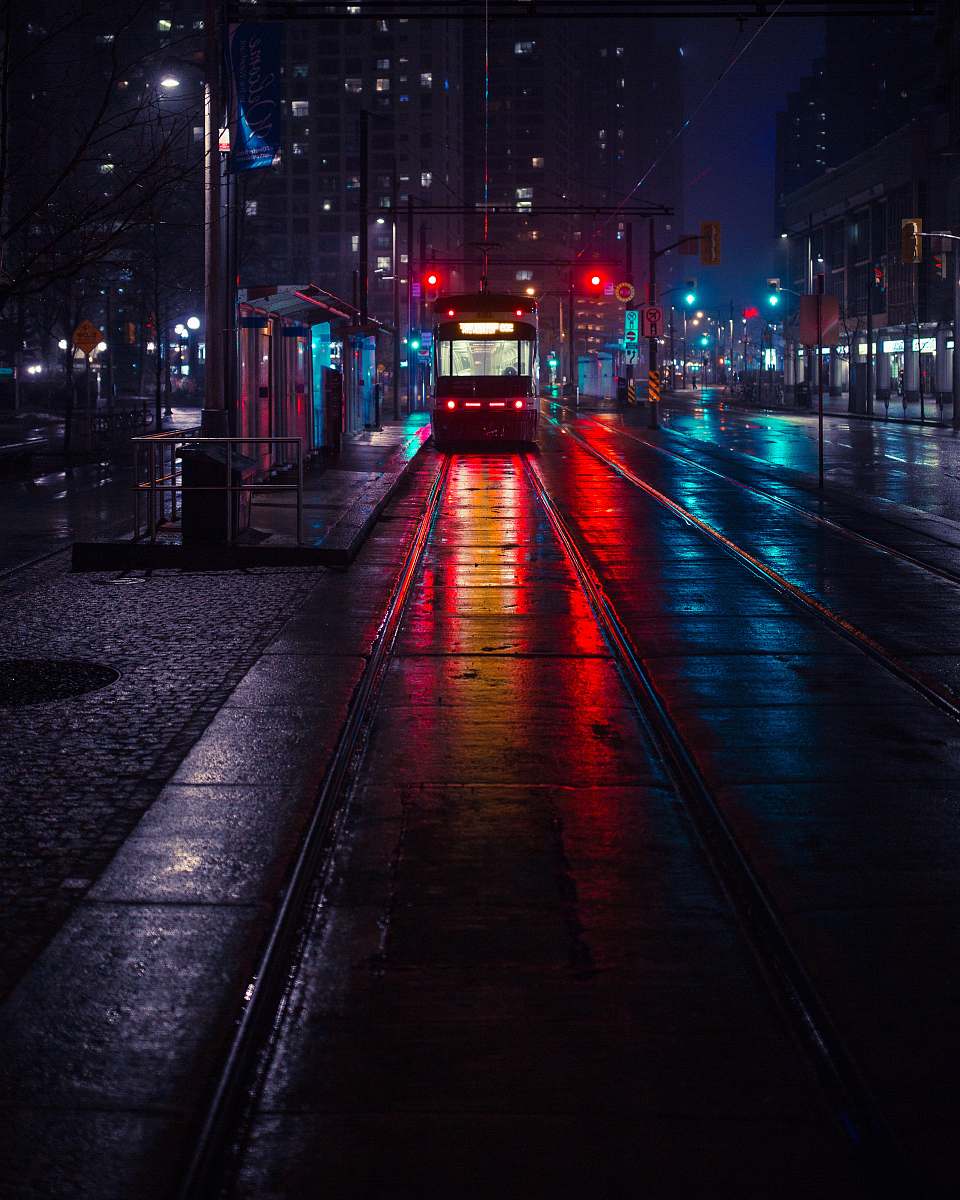 urban photo of tram beside waiting station during nighttime night