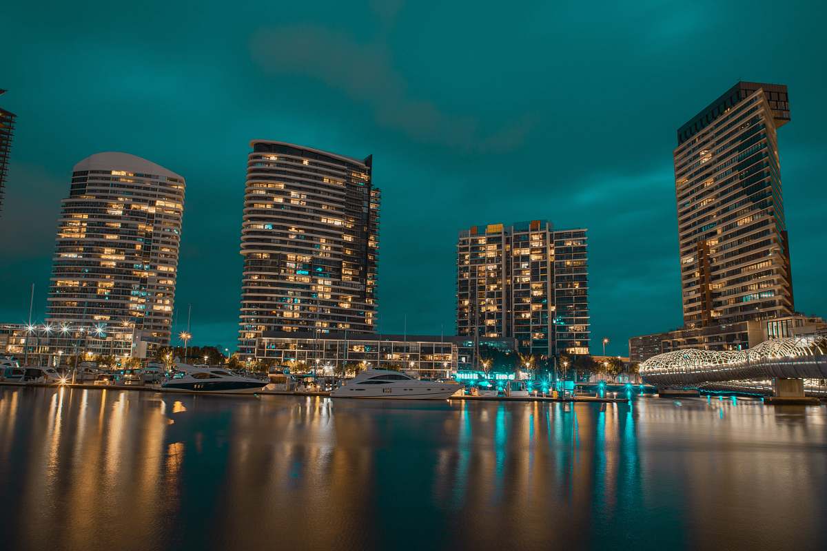 Experience the captivating scene of powerboats being expertly crafted in the tranquil waters of a bustling city. Set against a stunning nighttime skyline, this image beautifully captures the harmonious blend of urban development and marine craftsmanship. Ideal for use in travel blogs, promotional material for boat manufacturers, or as a striking visual for urban lifestyle publications.