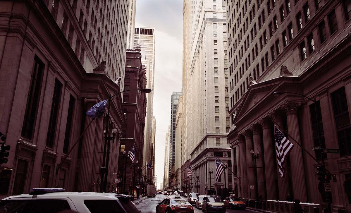building vehicles on concrete road between high buildings under white sky at daytime street