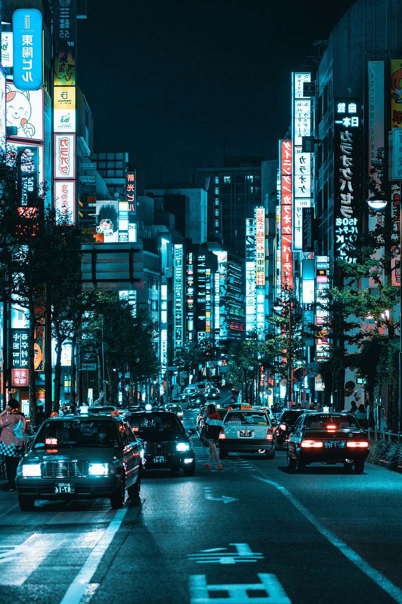 car vehicles on roadway between lighted buildings at night automobile