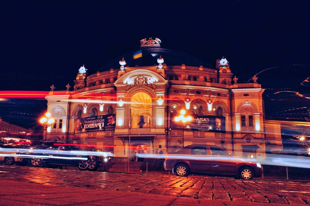 building vehicles travelling on road during nighttime time lapse photography town