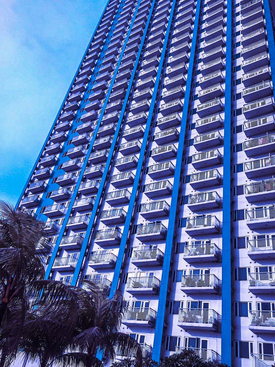 building view of white and blue painted apartment complex high rise